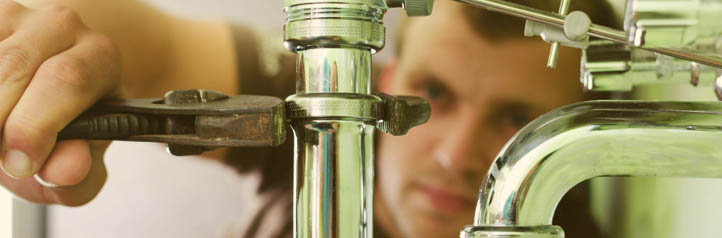 Plumber fixing a leaking pipe