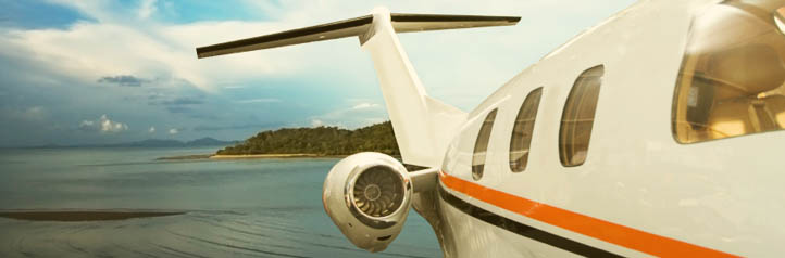 Chartered private jet flying over an island