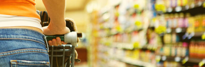 Shopper in supermarket with cart