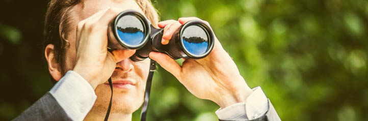 Business person conducting research with binoculars