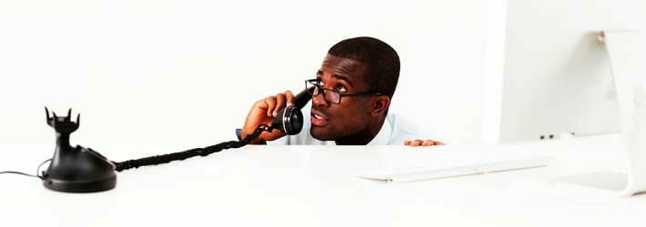 Businessman Hiding Behind Desk