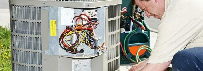 HVAC contractor welding an A/C unit